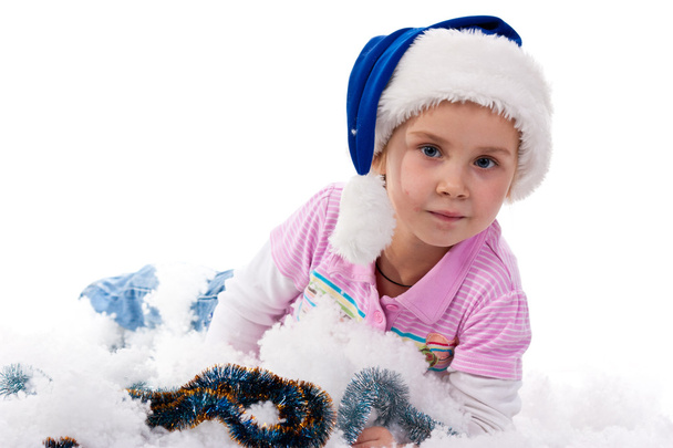 Beautiful girl in Santa's hat in tinsel and artificial snow isolated on white - Photo, Image