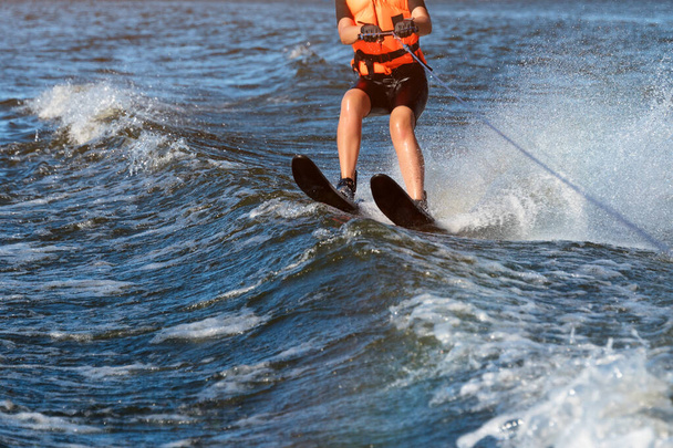 Woman riding water skis closeup. Body parts without a face. Athlete water skiing and having fun. Living a healthy lifestyle and staying active. Water sports theme. Summer by the sea. - Photo, Image