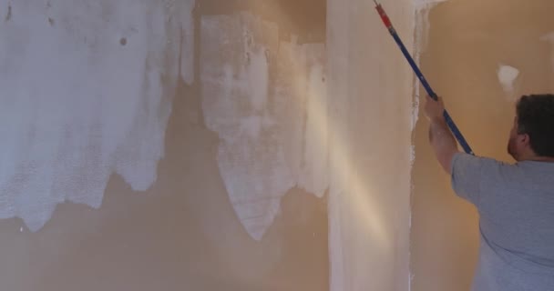 Ressam alçıtaşı sıva uyguladıktan sonra duvarı astar ile kapladı.. - Video, Çekim