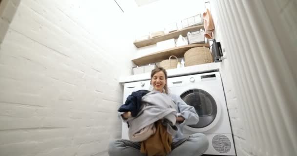 Femme au foyer vomissant des vêtements à la buanderie - Séquence, vidéo