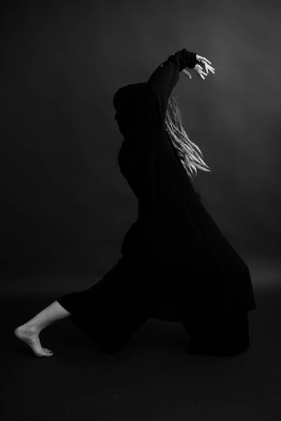 girl dancing in a black robe with a hood, art mystical photo - Valokuva, kuva