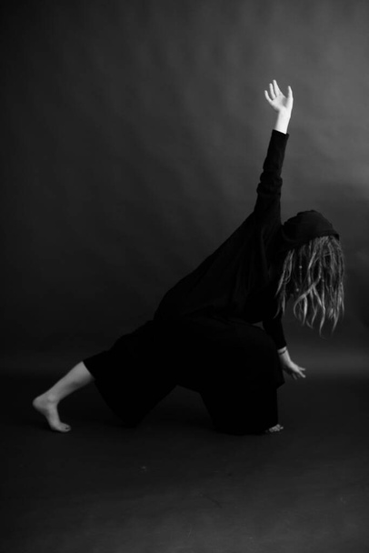 girl dancing in a black robe with a hood, art mystical photo - Fotoğraf, Görsel