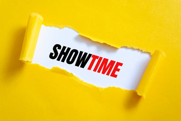Papel amarillo roto revelando la palabra Showtime - Foto, Imagen