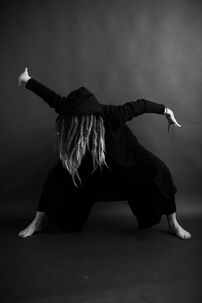 girl dancing in a black robe with a hood, art mystical photo - Zdjęcie, obraz
