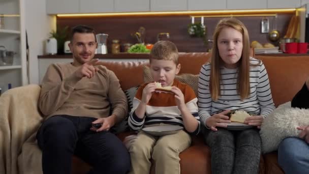 Famiglia sorda positiva che guarda la TV seduta sul divano - Filmati, video