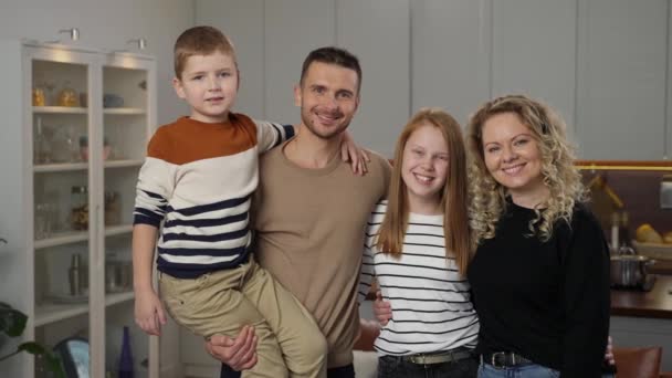 Ritratto di famiglia felice in posa sulla macchina fotografica a casa - Filmati, video