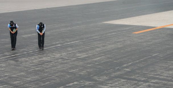 Uçak kalkınca havaalanı personeli eğiliyor, Naha havaalanı, Okinawa, Japonya - Fotoğraf, Görsel