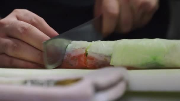 Unkenntlicher Ernte-Koch schneidet Brötchen, während er in der Küche eines asiatischen Cafés leckeres Gericht zubereitet - Filmmaterial, Video