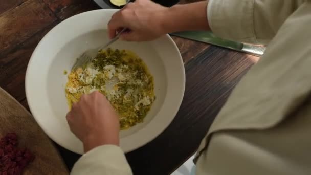 Hohe Winkel der anonymen Koch Hinzufügen verschiedener gehackter Zutaten in Schüssel mit Senf beim Kochen Steak Tatar Sauce - Filmmaterial, Video