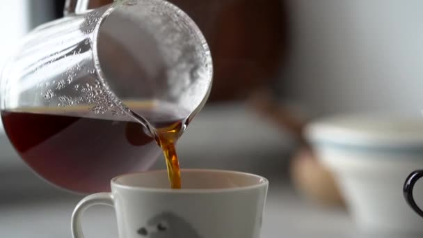 Crop fêmea anônima derramando café fresco quente fabricado a partir de jarro de vidro em copo na cozinha aconchegante em casa - Filmagem, Vídeo