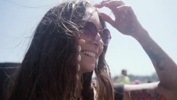 Крупный план замедленной съемки восхитительной молодой женщины-путешественницы с пирсингом и стильными солнечными очками, наслаждающейся свежестью водопадов во время посещения водопада Монморанси в Канаде в солнечный летний день - Кадры, видео