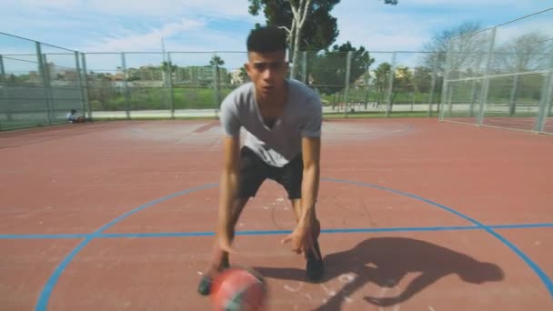 Nyomkövető lövés afro-amerikai sportoló kezd csöpög labda, majd próbál végre sikertelen slam zsákolás lövés gyűrű alatt kosárlabda edzés a sportpályán - Felvétel, videó