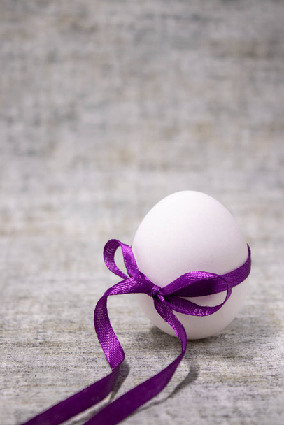 jajko kurze zawinięte w fioletowy węzeł. zdrowa surowa żywność. jaja wielkanocne, obecne. - Zdjęcie, obraz