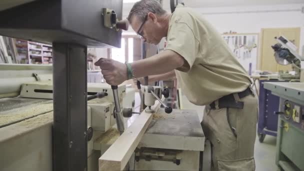 現代の作業室での勤勉な大工の掘削木材 - 映像、動画