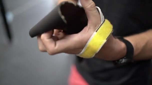 Nerozpoznatelný muž omotávající gumičku kolem zápěstí při přípravě na trénink v tělocvičně - Záběry, video