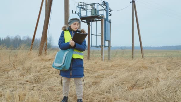 Woman electrical engineer examining power line - Footage, Video