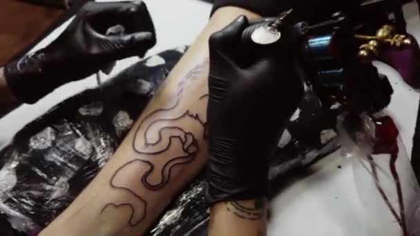 Crop master τατουάζ κάνει περίγραμμα στο πόδι του πελάτη - Πλάνα, βίντεο