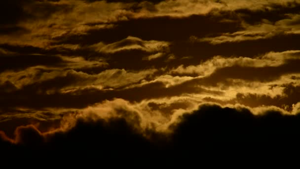 Tijdsverloop van schilderachtig uitzicht op heldere oranje zon die ondergaat in de lucht met wolken bij zonsondergang - Video