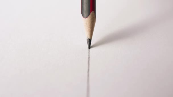 Tracking shot rysunku ołówka prostej linii na gładkiej białej powierzchni - Materiał filmowy, wideo