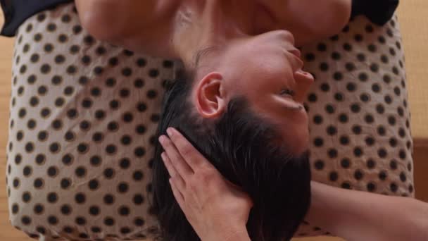 Зверху розслаблена жінка насолоджується альтернативним обличчям аюрведичної терапії Марма під час масажного лікування в спа-салоні
 - Кадри, відео