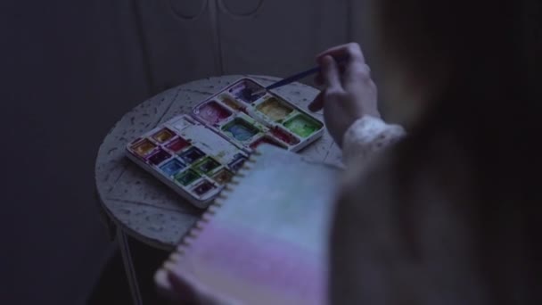Спокійна жінка малює в щоденнику, сидячи на стільці
 - Кадри, відео