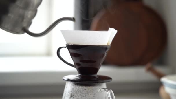 Meleg víz papírszűrőbe friss őrölt kávéval történő öntésének oldalnézeti folyamata aromás forró ital készítése során - Felvétel, videó