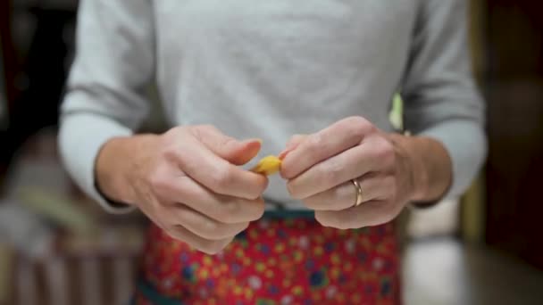 Ritaglio anonimo femminile in piedi con i tradizionali tortellini italiani in cucina a casa - Filmati, video
