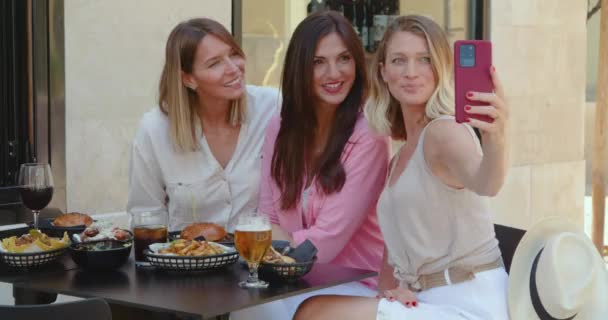 Μοντέρνο κομψό γυναικών που συγκεντρώνονται για γεύμα με ποτά στο πεζοδρόμιο καφέ και τη λήψη selfie με smartphone το καλοκαίρι - Πλάνα, βίντεο