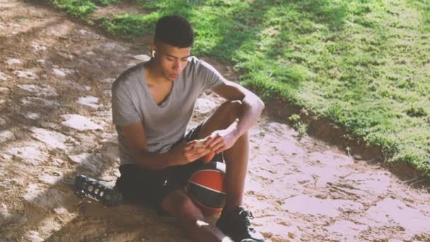 Deportista negro leyendo mensajes durante el descanso - Metraje, vídeo