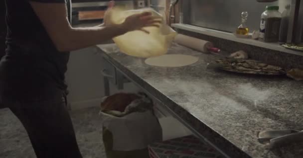 Crop férfi séf portalanító asztal liszttel és kezd nyúlik tészta főzés közben pizza étterem konyhájában - Felvétel, videó