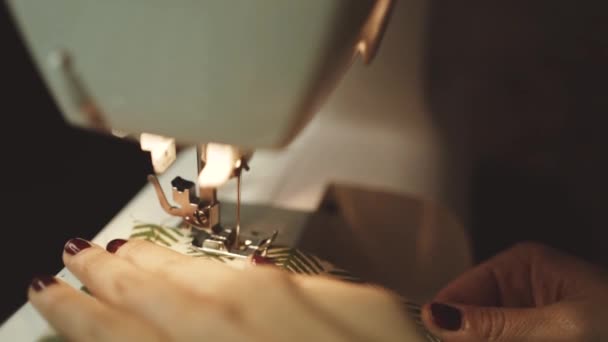 nerozpoznatelná řemeslnice používající moderní šicí stroj při vytváření měkkých textilních vzorků s kreativním zeleným vzorem v blízkosti lampy v dílně ve stylu podkroví - Záběry, video