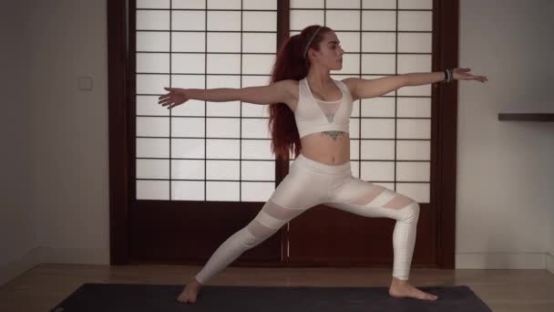 Jeune rousse femme faire du yoga sur tapis à la maison - Séquence, vidéo