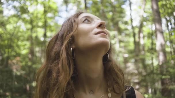 Alacsony szögű lövés egy nő az erdő közepén, látva a táj - Felvétel, videó