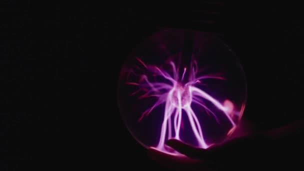 Abstrakcyjny wzór neonowego światła w kształcie neuronu stworzony przez świecącą kulę plazmową na czarnym tle - Materiał filmowy, wideo