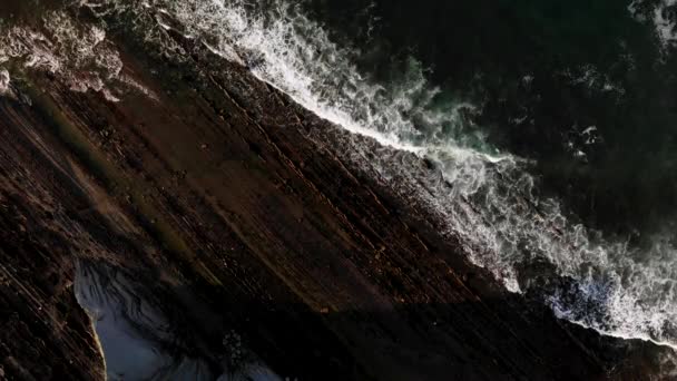 Вид беспилотника на захватывающий пейзаж пенного моря, катящегося по бурному каменистому побережью Зумаи - Кадры, видео