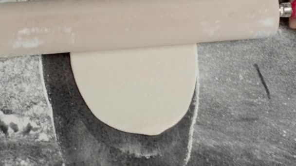 Зверху відстежуючий знімок анонімного шеф-кухаря розтягує тісто з прокатним штифтом під час роботи на кухні
 - Кадри, відео