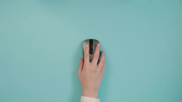 Из выше урожая анонимный человек, нажав беспроводную кнопку мыши компьютера на синем фоне в студии - Кадры, видео