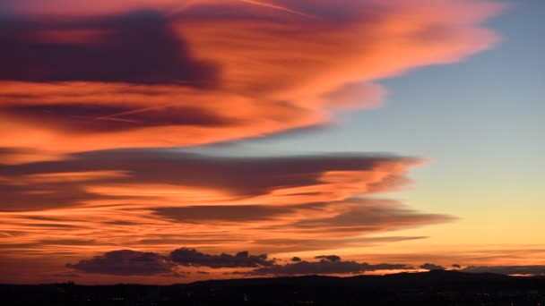 Tijd verstrijken van kleurrijke zonsondergang hemel met wolken over de stad met verlichting in de avond - Video