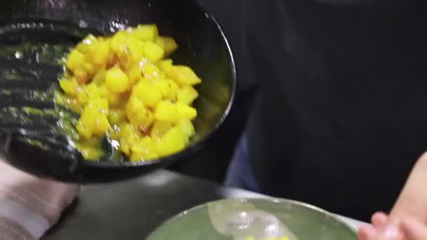 Μη αναγνωρίσιμο μάγειρα βάζοντας ορεκτικό μαγειρεμένες πατάτες σε μπολ, ενώ προετοιμασία πιάτο για το σερβίρισμα στο εστιατόριο - Πλάνα, βίντεο