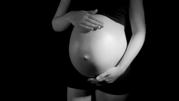 zwangere vrouw wrijft buik in zwart-wit - Video