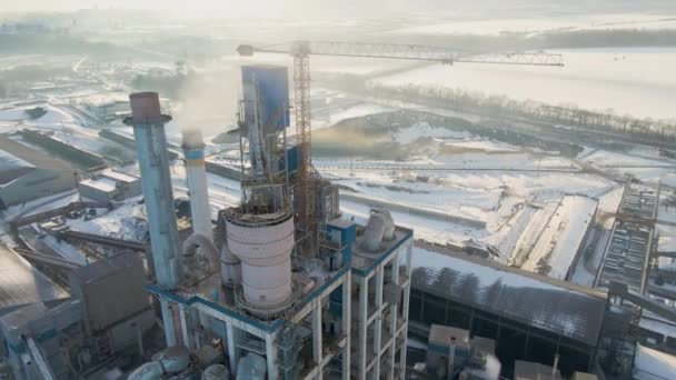 Widok z lotu ptaka cementowni o wysokiej strukturze fabrycznej i żurawia wieżowego na przemysłowym obszarze produkcji. - Materiał filmowy, wideo