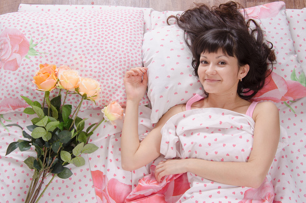słodkie dziewczyny w łóżku zaskoczony dalem bukiet róż - Zdjęcie, obraz