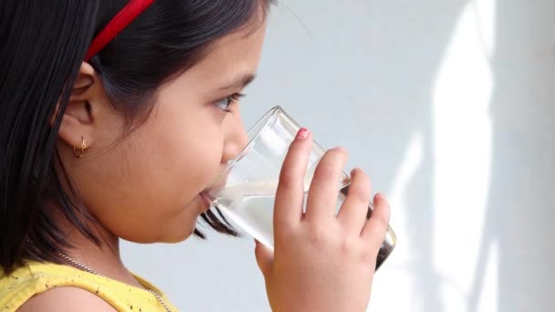 zij hoek close-up uitzicht van een Indiaas meisje drinken water uit een glas - Video