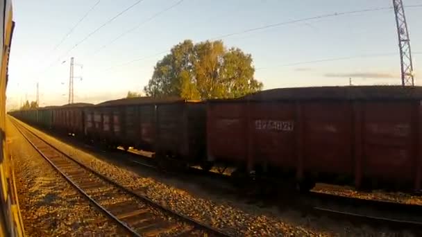 Tren que pasa por un tren de mercancías al final del día
 - Imágenes, Vídeo