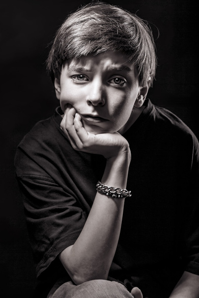 black and white portrait of a male teenager with black backgroun - Фото, изображение