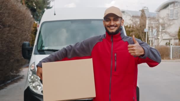 Thumb up. Young courier delivering parcel and showing thumb up in front of the van - Footage, Video