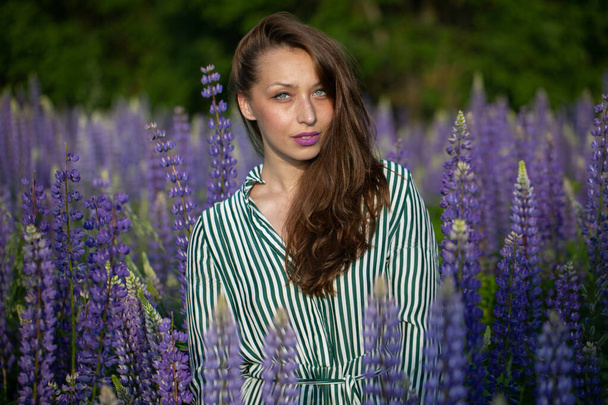 Menina bonita lindo com cabelo escuro magnífico posando no prado florescendo - Foto, Imagem