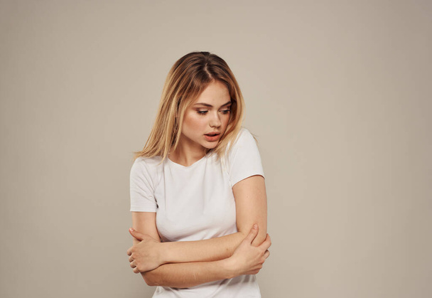 Schöne Blondine in weißem T-Shirt auf grauem Hintergrund - Foto, Bild