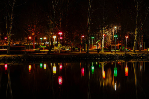 Trollhattan, Schweden Ein öffentlicher Park am Gota-Kanal erleuchtet mit Lichtern. - Foto, Bild