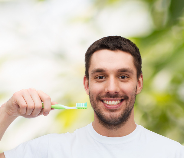 Smiling young man with toothbrush - Foto, Imagem